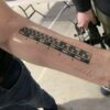 What is tattooed on Adam Savage's arm?