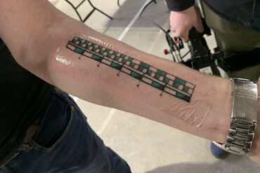 What is tattooed on Adam Savage's arm?