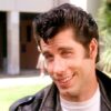 Does Travolta sing in Grease?