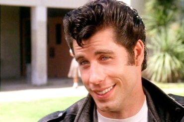 Does Travolta sing in Grease?